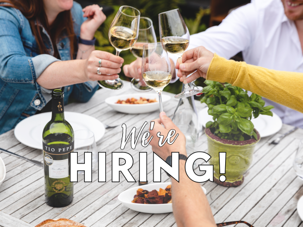 people clinking glasses with we're hiring text
